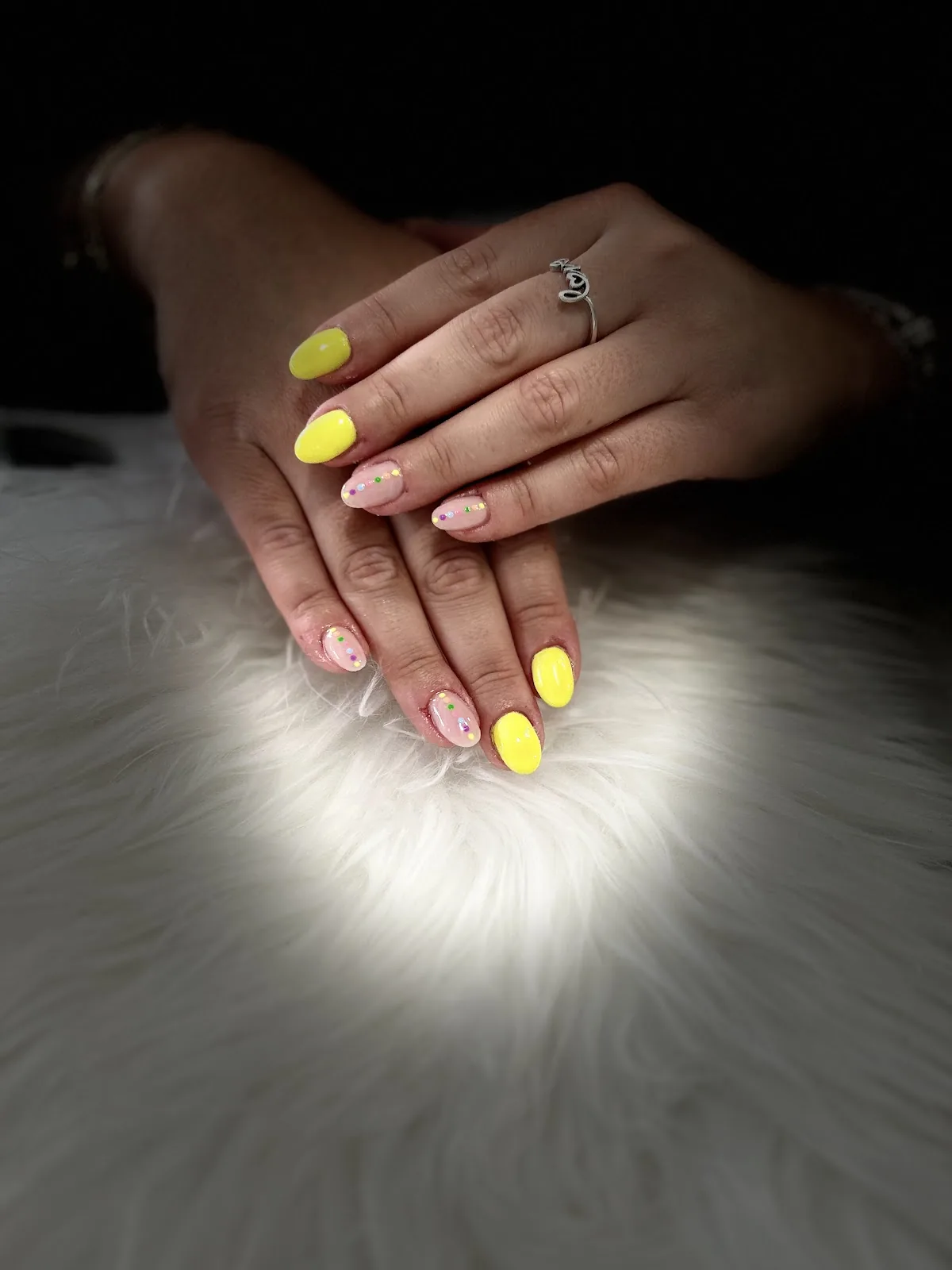 Uñas amarillas y rosas sobre pelo blanco