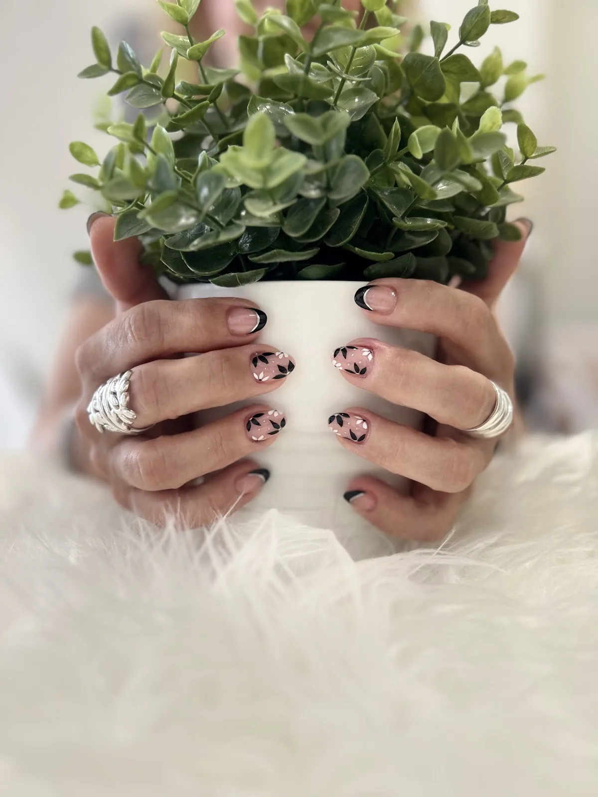 Manos con nail art sujetando una planta