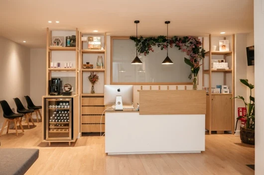 Recepción de Instituto Zentro con madera clara y decoración vegetal