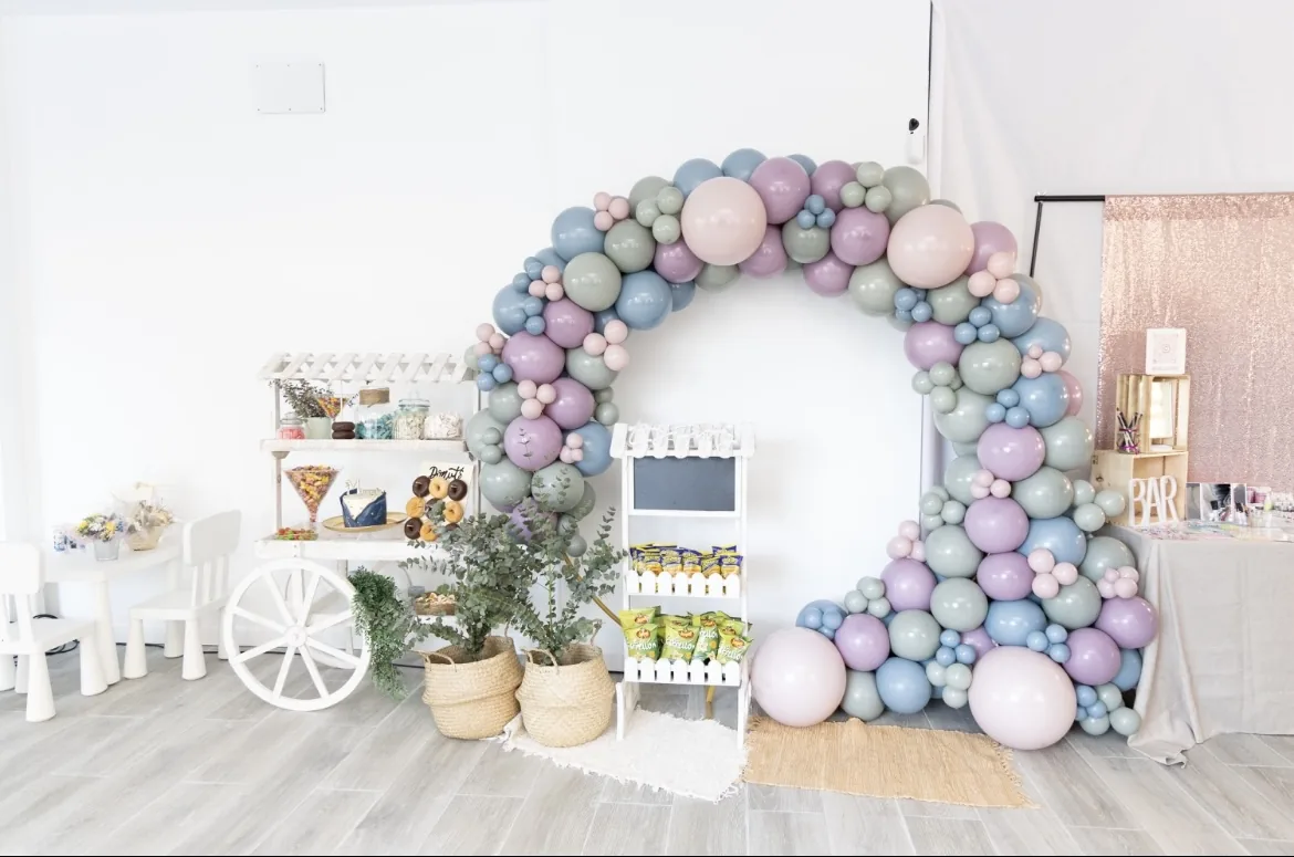 Arco de globos y mesa dulce montados en el salón