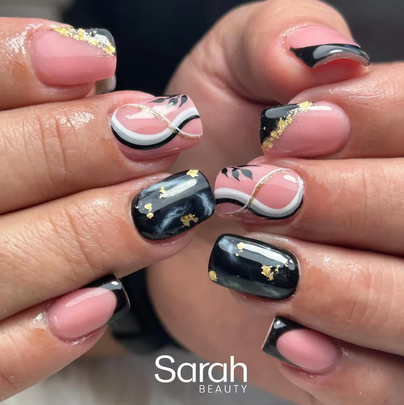 Uñas negras con detalles dorados